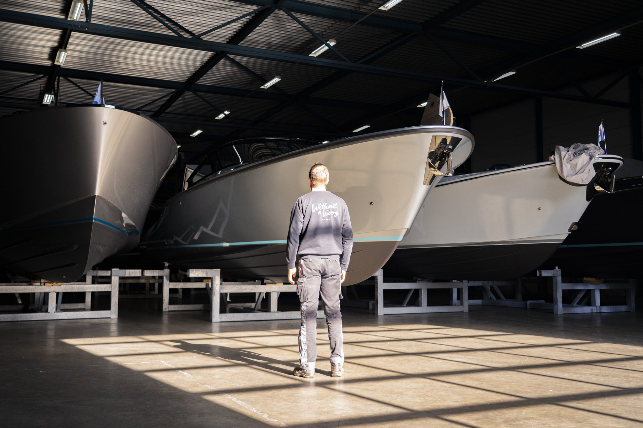 Motor yachts stored on steel cradles in a clean, well-lit storage building